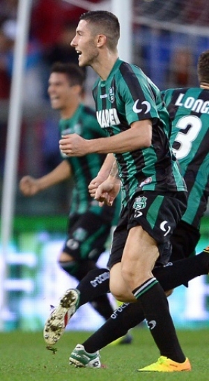 Sassuolo's forward Domenico Berardi (L) celebrates with teamates after scoring and equilizing against AS Roma during the Italian Serie A football match between AS Roma and Sassuolo at Rome's Olympic stadium on November 10, 2013. AFP PHOTO /Filippo MONTEFORTE