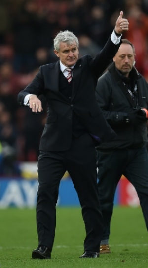 Stoke City's Welsh manager Mark Hughes gestures to the fans following the English Premier League football match between Stoke City and Manchester City at the Britannia Stadium in Stoke-on-Trent, central England on December 5, 2015. Stoke won the match 2-0. AFP PHOTO / PAUL ELLIS RESTRICTED TO EDITORIAL USE. No use with unauthorized audio, video, data, fixture lists, club/league logos or 'live' services. Online in-match use limited to 75 images, no video emulation. No use in betting, games or single club/league/player publications..