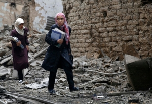 S&iacute;rias caminham em meio a edif&iacute;cios destru&iacute;dos em Douma