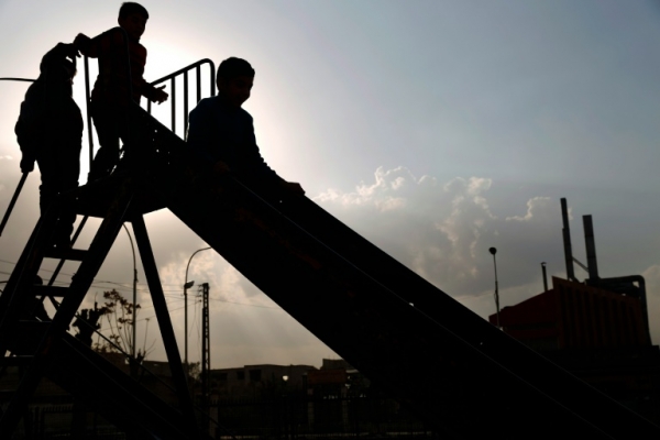 Crian&ccedil;as s&iacute;rias brincam num parque da cidade de Duma no primeiro dia de tr&eacute;gua na Siria