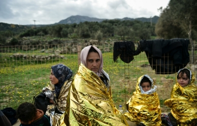 (Arquivo) Uma fam&iacute;lia de migrantes espera por ajuda humanit&aacute;ria, na ilha grega de Lesbos, em 25 de novembro de 2015