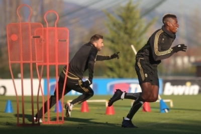 Juventus' French midfielder Paul Pogba (R) takes part in a training session at the Juventus Training Center in Vinovo, near Turin, on November 24, 2015, on the eve of the UEFA Champions League football match Juventus vs Manchester City. AFP PHOTO / MARCO BERTORELLO