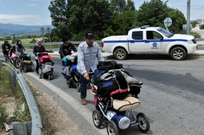 Migrantes e refugiados deixam o campo de Idomeni, no dia 25 de maio de 2016