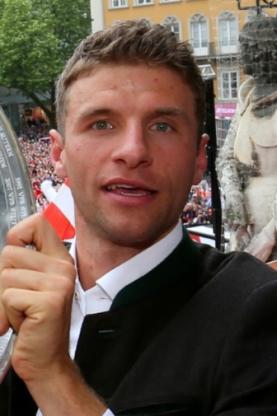 Thomas Mueller of Bayern Munich holds the trophy as they celebrate winning the club's 25th German football first division Bundesliga title on the balcony of the city hall at the Marienplatz in Munich, southern Germany on May 24, 2015. AFP PHOTO / POOL / ALEXANDER HASSENSTEIN