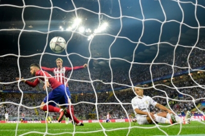Atletico Madrid's Belgian forward Yannick Ferreira Carrasco (L) reacts after scoring a goal during the UEFA Champions League final football match between Real Madrid and Atletico Madrid at San Siro Stadium in Milan, on May 28, 2016.