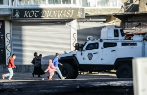 Moradores passam por blindados das for&ccedil;as especiais turcas em Sirnak, sudeste do pa&iacute;s, durante opera&ccedil;&otilde;es contra rebeldes curdos nas cidadez vizinhas de Cizre e Silopi, em 22 de dezembro de 2015