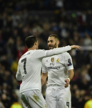 Real Madrid's French forward Karim Benzema (R) celebrates with Real Madrid's Portuguese forward Cristiano Ronaldo after scoring his third goal during the UEFA Champions League Group A football match Real Madrid CF vs Malmo FF at the Santiago Bernabeu stadium in Madrid on December 8, 2015. AFP PHOTO/ PIERRE-PHILIPPE MARCOU