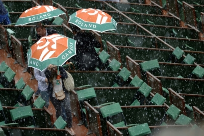 Espectadores deixam as arquibancadas para tentar se proteger da chuva, em 28 de maio, em Roland Garros