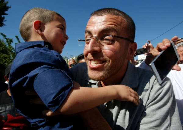 O jornalista palestino Mohamed al Qiq abra&ccedil;a seu filho ap&oacute;s ser libertado, em Dura, na Cisjord&acirc;nia, no dia 19 de maio de 2016