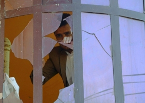 Um homem afeg&atilde;o &eacute; vistoo atrav&eacute;s de uma janela quebrada ap&oacute;s o atentado pr&oacute;ximo ao consulado indiano em Jalalabad no dia 5 de janeiro de 2016