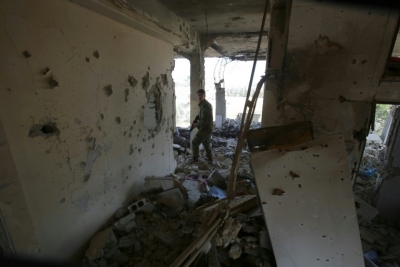 (Fevereiro) Membro das for&ccedil;as do governo s&iacute;rio em meio a escombros de um pr&eacute;dio em Daraya