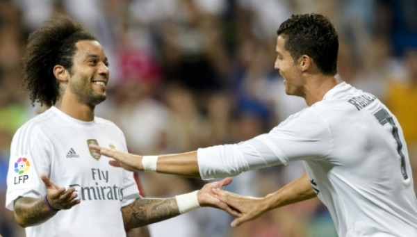 Real Madrid's Brazilian defender Marcelo (L) celebrates a goal with teammate Real Madrid's Portuguese forward Cristiano Ronaldo (R) during the Trofeo Santiago Bernabeu football match Real Madrid vs Galatasaray at the Santiago Bernabeu stadium in Madrid on August 18, 2015. AFP PHOTO / DANI POZO