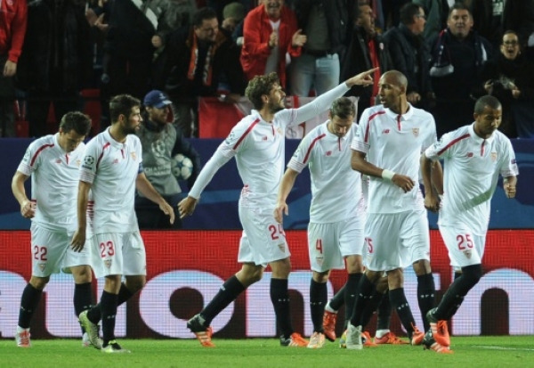 Sevilla's Spanish forward Fernando Llorente (C) celebrates with teammates after scoring a goal during the UEFA Champions League Group D football match Sevilla FC vs Juventus at the Ramon Sanchez Pizjuan stadium in Sevilla on December 8, 2015. AFP PHOTO/ CRISTINA QUICLER