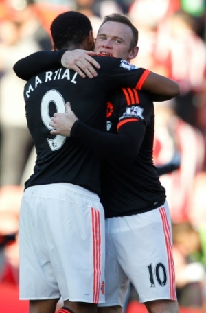 Manchester United's English striker Wayne Rooney embraces Manchester United's French striker Anthony Martial (L) after the English Premier League football match between Southampton and Manchester United at St Mary's Stadium in Southampton, southern England on September 20, 2015. Manchester United won the game 3-2. AFP PHOTO / IAN KINGTON RESTRICTED TO EDITORIAL USE. No use with unauthorized audio, video, data, fixture lists, club/league logos or 'live' services. Online in-match use limited to 75 images, no video emulation. No use in betting, games or single club/league/player publications.