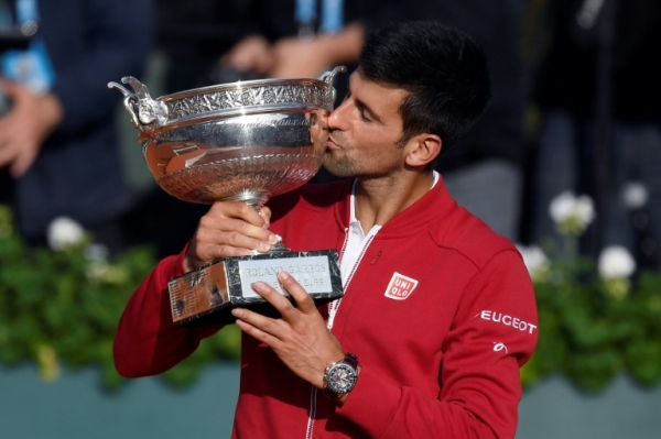 Novak Djokovic beija o trof&eacute;u depois de conquistar pela primeira vez o torneio de Roland Garros, em 5 de junho, em Paris