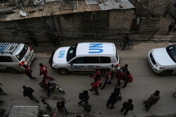 Carros da ONU escoltam um comboio do Crescente Vermelho, que transporta ajuda humanit&aacute;ria, na chegada a Kafr Batna, na S&iacute;ria, em 23 de fevereiro de 2016
