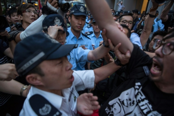 Policiais controlam um manifestante pr&oacute;-democracia em Hong Kong