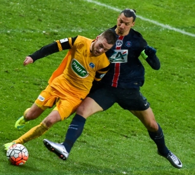 Paris Saint-Germain's Swedish forward Zlatan Ibrahimovic (R) vies with Wasquehal's defender Pierre Planque during the French Cup football match Wasquehal vs PSG on Janury 03, 2016 at the Lille Metropole stadium in Villeneuve-d'Ascq ,northern France.