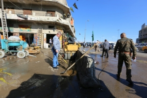 V&aacute;rias pessoas limpam palco de atentado em Bagd&aacute; em 29 de mar&ccedil;o de 2016