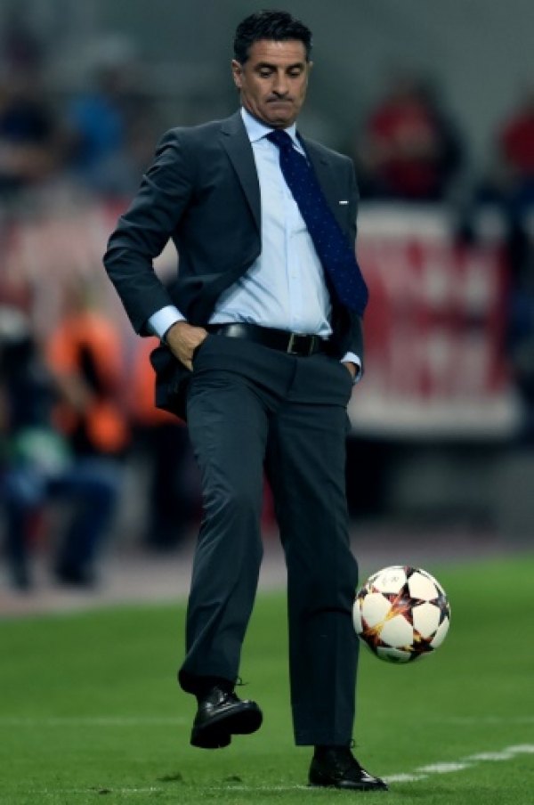 Olympiacos' head coach Michel, whose full name is Jose Miguel Gonzalez Martin del Campo, kicks the ball during the Group A Champions League football match Olympiacos vs Juventus at the Karaiskaki stadium in Athens' Piraeus district on October 22, 2014. AFP PHOTO / ARIS MESSINIS