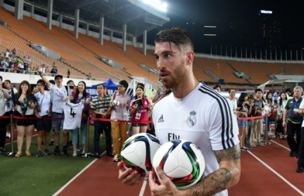 Real Madrid's defender Sergio Ramos holds two ball after a training session on the eve of the International Champions Cup football match between Inter Milan and Real Madrid in Guagnzhou on July 26, 2015. AFP PHOTO / JOHANNES EISELE