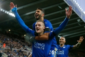 Leicester City's English striker Jamie Vardy (Below L) celebrates after scoring his team's first goal during the English Premier League football match between Newcastle United and Leicester City at St James' Park in Newcastle-upon-Tyne, north east England, on November 21, 2015. AFP PHOTO / LINDSEY PARNABY RESTRICTED TO EDITORIAL USE. No use with unauthorized audio, video, data, fixture lists, club/league logos or 'live' services. Online in-match use limited to 75 images, no video emulation. No use in betting, games or single club/league/player publications.