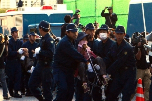 (Arquivo) Policiais removem manifestantes de um port&atilde;o da base americana de Nago, na ilha de Okinawa