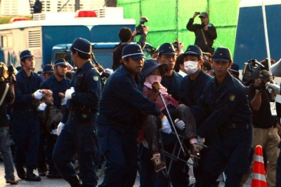(Arquivo) Policiais removem manifestantes de um port&atilde;o da base americana de Nago, na ilha de Okinawa