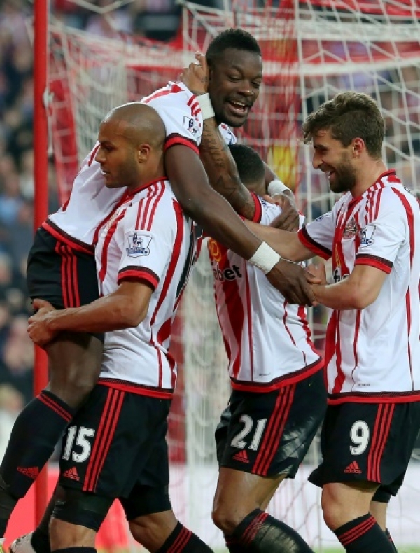 Sunderland's French-born Ivorian defender Lamine Kone (Top) celebrates after scoring his team's third goal during the English Premier League football match between Sunderland and Everton at the Stadium of Light in Sunderland, north east England on May 11, 2016.