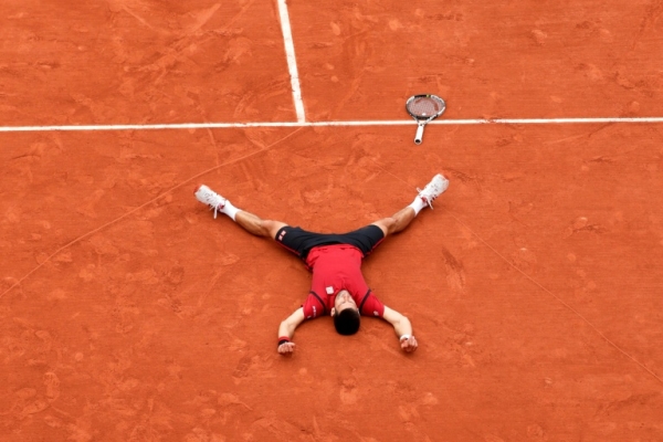 Djokovic deitado no meio do cora&ccedil;&atilde;o que desenhou na quadra de Roland Garros, em 5 de junho, em Paris