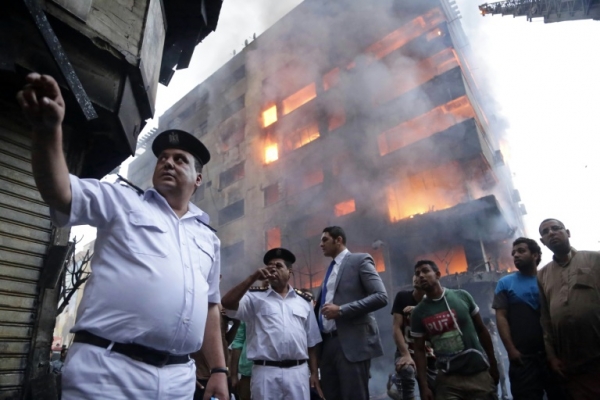 Policiais, bombeiros e cidad&atilde;os eg&iacute;pcios s&atilde;o vistos perto do local do inc&ecirc;ndio, no centro de Cairo, em 9 de maio de 2016