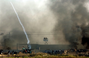 Palestinos enfrentam for&ccedil;as israelenses diante da barreira que separa o territ&oacute;rio hebreu da Faixa de Gaza.