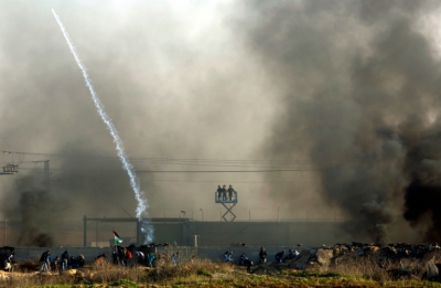 Palestinos enfrentam for&ccedil;as israelenses diante da barreira que separa o territ&oacute;rio hebreu da Faixa de Gaza.