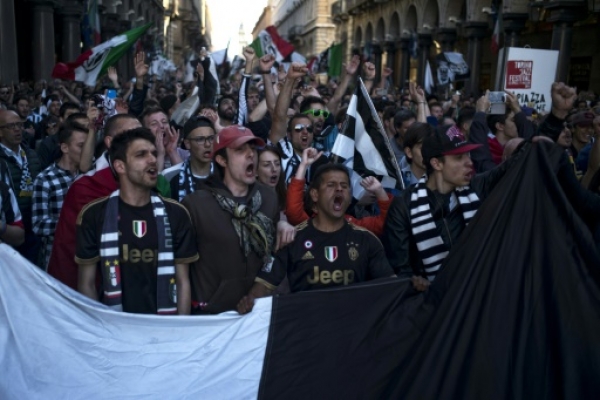 Juventus supporters celebrate after their football club won the Italian Serie A "Scudetto" in Piazza San Carlo in Turin on April 25, 2016. Defending champions Juventus mathematically secured a record-equalling fifth consecutive Serie A title today after Roma stunned second-placed Napoli with a last-gasp winner. Juventus won their fifth consecutive and 34th official Serie A title.