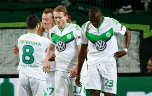 Wolfsburg's players celebrate after midfielder Maximilian Arnold (2nd L) scored the 2-0 goal during the UEFA Champions League quarter-final, first-leg football match between VfL Wolfsburg and Real Madrid on April 6, 2016 in Wolfsburg, northern Germany.