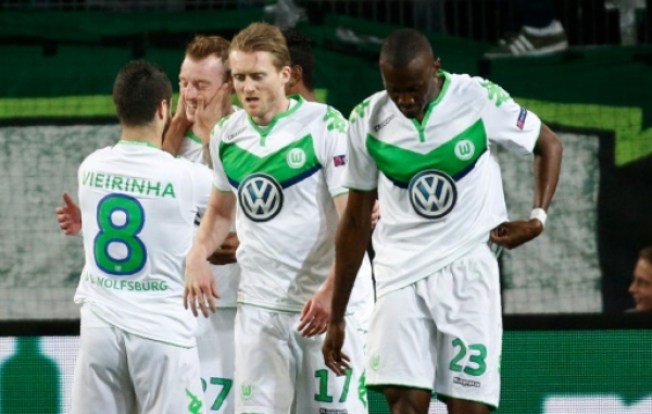 Wolfsburg's players celebrate after midfielder Maximilian Arnold (2nd L) scored the 2-0 goal during the UEFA Champions League quarter-final, first-leg football match between VfL Wolfsburg and Real Madrid on April 6, 2016 in Wolfsburg, northern Germany.