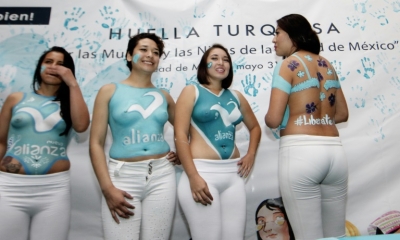 As meninas tamb&eacute;m posaram de costas, mostrando a pintura de um suti&atilde; azul com o fecho aberto e o pedido 'Liberte-se'