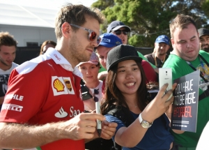 O piloto da Ferrari Sebastian Vettel posa com uma f&atilde; em Melbourne