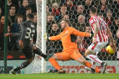 Liverpool's English midfielder Jordon Ibe (L) strikes the ball past Stoke City's English goalkeeper Jack Butland (C) to score the opening goal during the English League Cup semi-final first leg football match at Britannia Stadium in Stoke-on-Trent, central England, on January 5, 2015. AFP PHOTO / OLI SCARFF RESTRICTED TO EDITORIAL USE. No use with unauthorized audio, video, data, fixture lists, club/league logos or 'live' services. Online in-match use limited to 75 images, no video emulation. No use in betting, games or single club/league/player publications.
