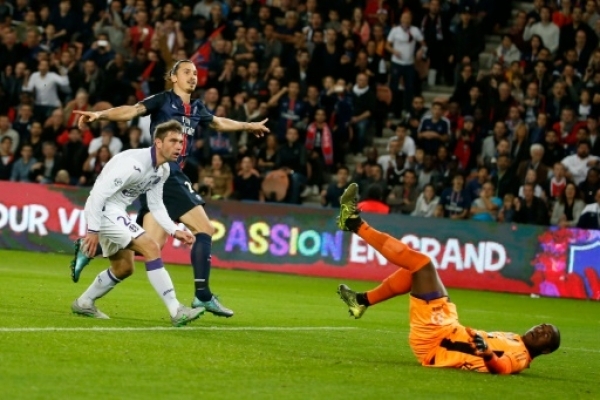 Paris Saint-Germain's Swedish forward Zlatan Ibrahimovic (C) scores during the French L1 football match between Paris Saint-Germain(PSG) and Toulouse (TFC) on November 7, 2015 at the Parc des Princes stadium, in Paris. AFP PHOTO / THOMAS SAMSON