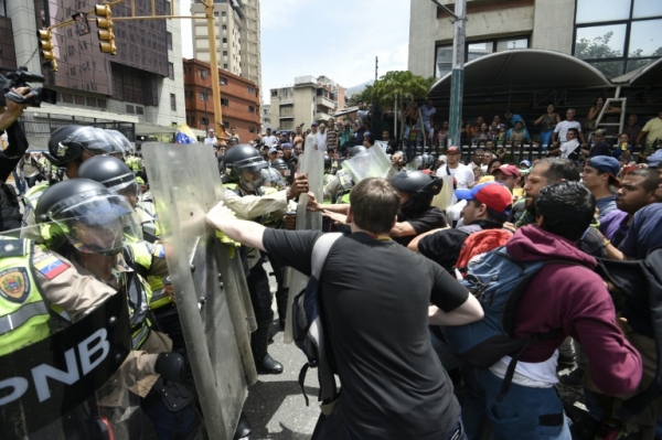 Policiais entram em confronto com manifestantes, em Caracas, no dia 18 de maio de 2016
