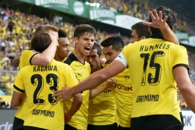 Dortmund's player celebrate during the German first division Bundesliga football match Borussia Dortmund vs Borussia Moenchengladbach in Dortmund, western Germany, on August 15, 2015. AFP PHOTO / PATRIK STOLLARZ RESTRICTIONS: DURING MATCH TIME: DFL RULES TO LIMIT THE ONLINE USAGE TO 15 PICTURES PER MATCH AND FORBID IMAGE SEQUENCES TO SIMULATE VIDEO. == RESTRICTED TO EDITORIAL USE == FOR FURTHER QUERIES PLEASE CONTACT DFL DIRECTLY AT + 49 69 650050.