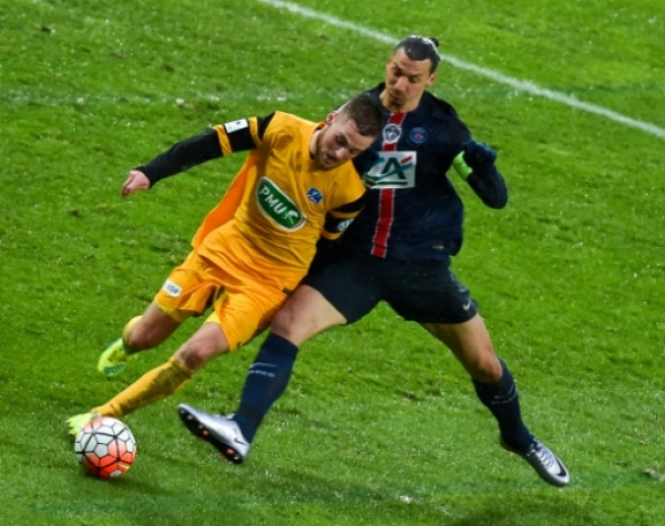 Paris Saint-Germain's Swedish forward Zlatan Ibrahimovic (R) vies with Wasquehal's defender Pierre Planque during the French Cup football match Wasquehal vs PSG on Janury 03, 2016 at the Lille Metropole stadium in Villeneuve-d'Ascq ,northern France.