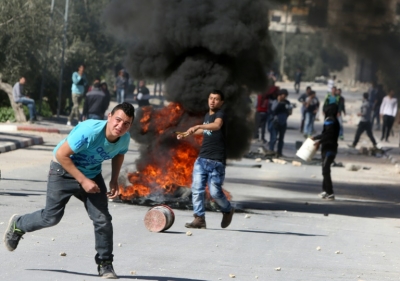 Jovens palestinos atiram pedras durante confronto com for&ccedil;as israelenses, em Araka, na Cisjord&acirc;nia ocupada, no dia 15 de fevereiro de 2016
