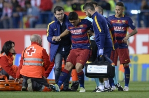 Barcelona's Uruguayan forward Luis Suarez (C) is assited after being injured beside Barcelona's Argentinian forward Lionel Messi during the Spanish "Copa del Rey" (King's Cup) final match FC Barcelona vs Sevilla FC at the Vicente Calderon stadium in Madrid on May 22, 2016.