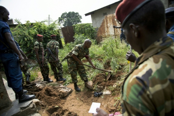 Militar do Burundi cava no jardim de uma casa de Buyumbura buscando poss&iacute;veis armas enterradas, em 11 de janeiro de 2016