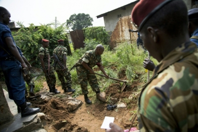 Militar do Burundi cava no jardim de uma casa de Buyumbura buscando poss&iacute;veis armas enterradas, em 11 de janeiro de 2016