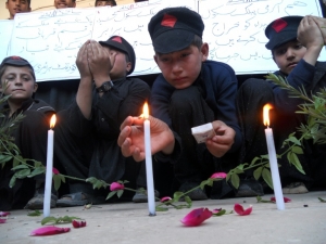 Estudante acende uma vela para lembrar o primeiro anivers&aacute;rio do atentado