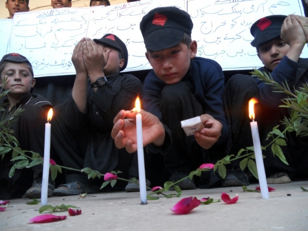 Estudante acende uma vela para lembrar o primeiro anivers&aacute;rio do atentado