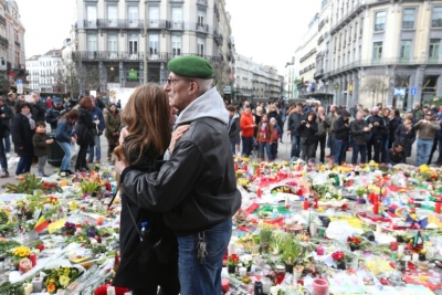 Casal se abra&ccedil;a em meio a flores em mem&oacute;ria das v&iacute;timas de atentados de Bruxelas, em 27 de mar&ccedil;o na capital belga